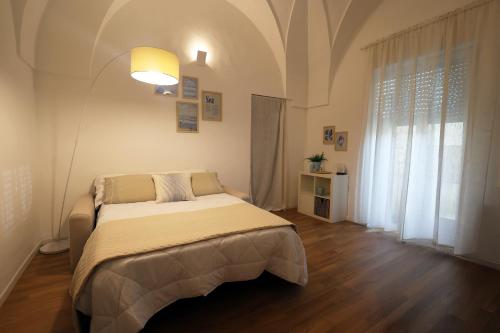 a bedroom with a bed and a large window at "CasaMia" Apartment - Brindisi Historic Center in Brindisi