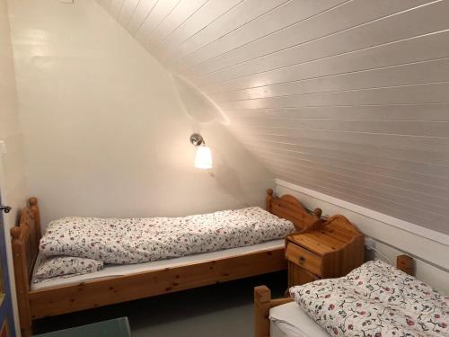 two twin beds in a room with a attic at Seaside apartment in farmhouse close to nature in Husevåg
