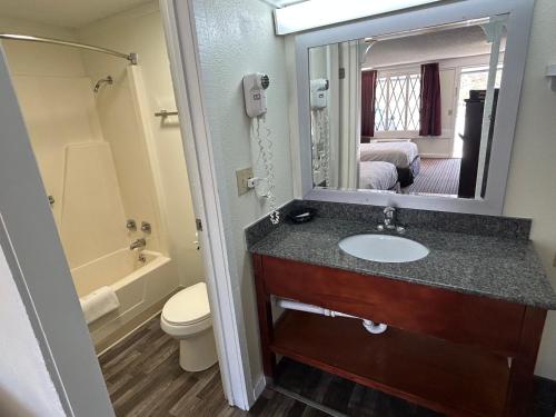 Un baño con lavabo, inodoro y espejo. en Knights Inn Somerset, en Somerset