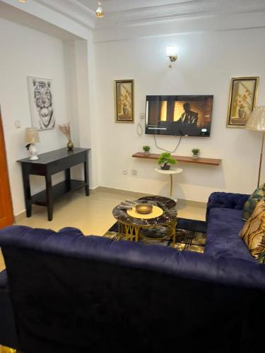 a living room with a blue couch and a piano at Lekker Estate in Yaoundé