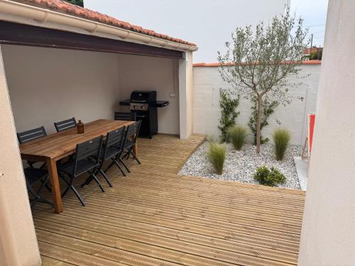 un patio extérieur avec une table et des chaises en bois dans l'établissement Villa Charlotte, 3 Chambres, Wifi, Terarsse, La Rochelle centre, à La Rochelle