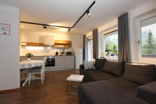 a living room with a couch and a table at Vila Edelweiss Rooms&App Kranjska Gora in Kranjska Gora