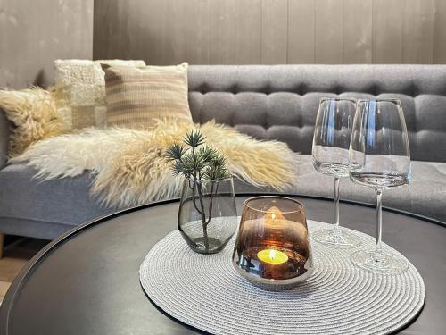 a table with two wine glasses and a candle on it at Fela Mirror Cabin Designer Hideaway 1000 m Above Sea Level in Aurdal