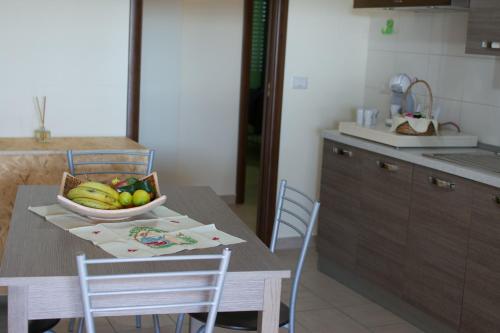 a kitchen with a table with a bowl of fruit on it at Civico 44 in Crotone