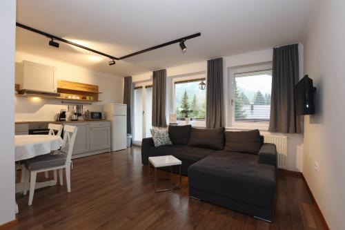 a living room with a couch and a table and a kitchen at Vila Edelweiss Rooms&App Kranjska Gora in Kranjska Gora