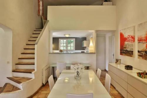 une salle à manger avec une table et des chaises blanches dans l'établissement Villa Lou, à Saint-Tropez