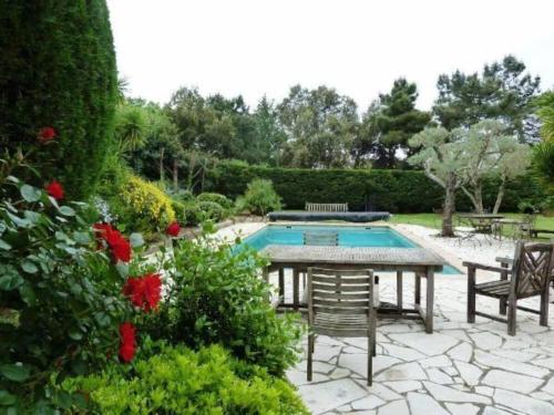 un patio avec une table et des chaises et une piscine dans l'établissement Villa Lou, à Saint-Tropez