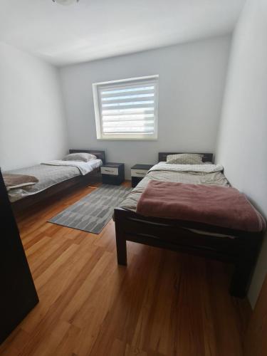 a bedroom with two beds and a window at Depandans Stefan in Nevesinje