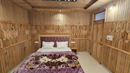 a bedroom with a bed in a wooden room at Freebird Nest Retreat in Jibhi
