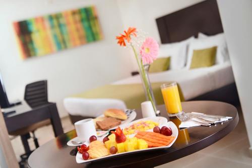 a tray of breakfast food on a table in a hotel room at Hotel Millenium Barrancabermeja in Barrancabermeja
