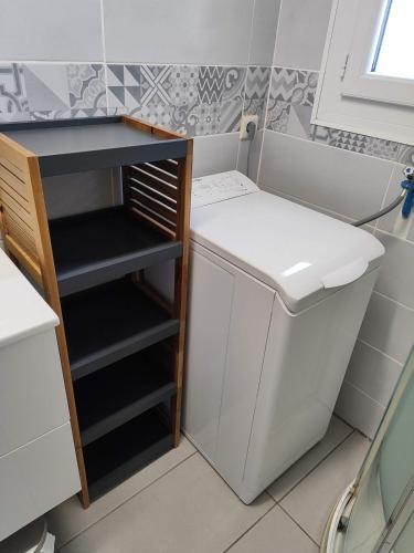 un petit réfrigérateur à côté d'un lavabo dans une salle de bain dans l'établissement L'Escapade Catalane - 4 pers - Plage&Port, à Saint Cyprien Plage