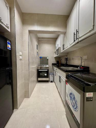 a kitchen with white cabinets and a sink and a counter at ALEX HOMES - Gleem Luxury Apartments with Direct Sea View in Alexandria