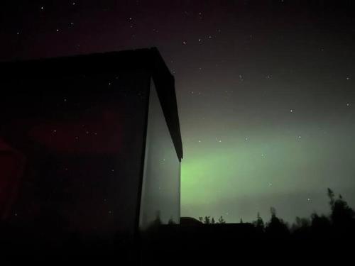 a night time view of a building in the sky at Fela Mirror Cabin Designer Hideaway 1000 m Above Sea Level in Aurdal