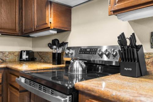 a kitchen with a stove and wooden cabinets at Mira Mesa Family Retreat 4BR with Balcony and Firepit in San Diego