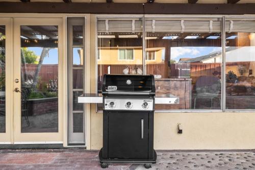 a grill in front of a building with glass doors at Mira Mesa Family Retreat 4BR with Balcony and Firepit in San Diego