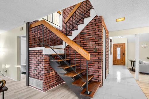 a brick wall with a staircase in a living room at Mira Mesa Family Retreat 4BR with Balcony and Firepit in San Diego