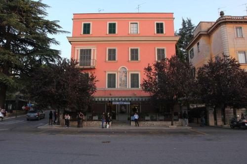 a large pink building with people standing in front of it at Palazzo Santori in Tivoli