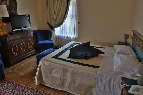 a bedroom with a bed and a tv in it at Hotel La Collegiata in San Gimignano