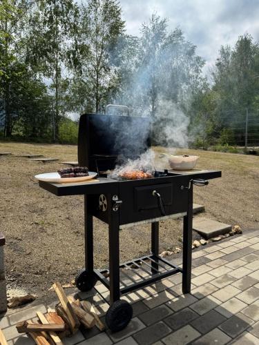 a bbq grill with a pan of food on it at Cabana Luminis in Râşnov