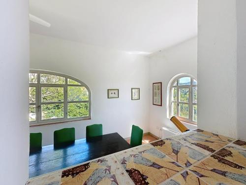 a bedroom with a large bed and two windows at Casa Belvedere di Bolgheri in Bolgheri