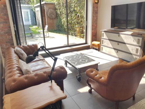 salon z kanapą, krzesłami i telewizorem w obiekcie spacieuse maison de ville avec espace détente w mieście Rezé