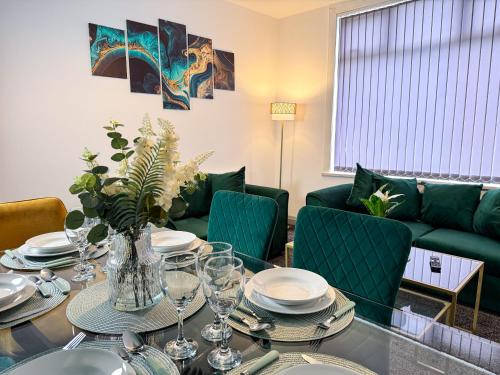 a dining room with a table and green furniture at Hambledon House 4BR Entire Home in Middlesbrough