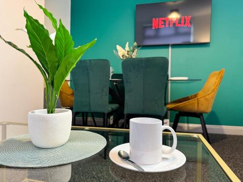 a table with two mugs and a plant on it at Hambledon House 4BR Entire Home in Middlesbrough