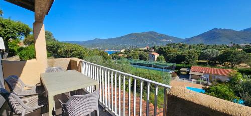 d'un balcon avec une table, des chaises et des montagnes. dans l'établissement T2 Résidence Dolce & Vita C5 vue mer et piscine, à Propriano
