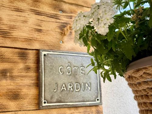 a sign that says cafe jardin on a wall with flowers at Une nuit en Luberon in Puyvert