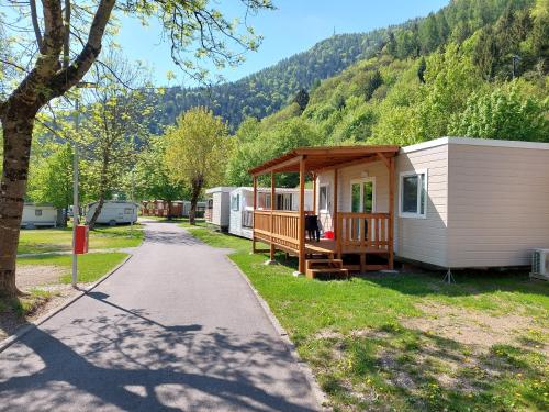 a mobile home with a gazebo next to a road at Camping Al Lago Ledro in Ledro