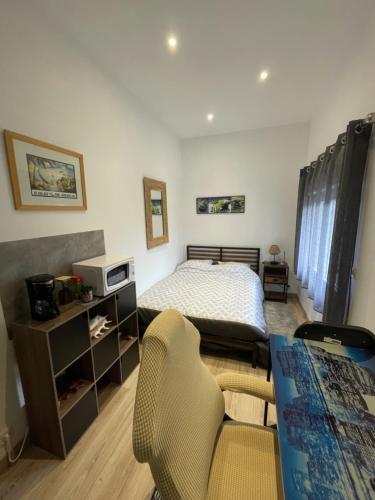 - une chambre avec un lit et un bureau avec des chaises dans l'établissement Chambre dans maison individuelle avec climatisation, à Saint-Jean-de-Védas