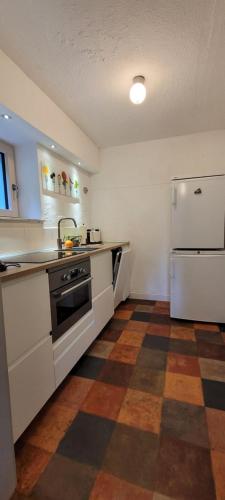 a kitchen with a sink and a refrigerator at Fast wie zu Hause in Jettingen-Scheppach