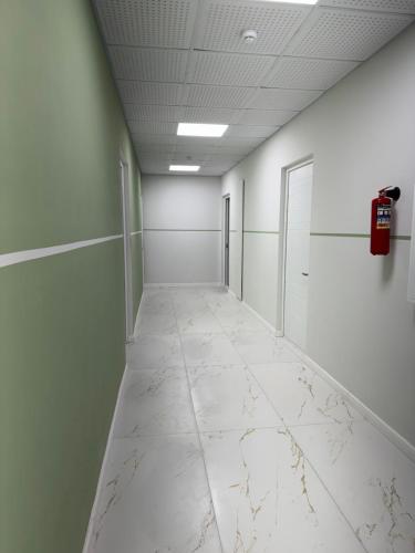 an empty hallway with white walls and a fire extinguisher at DiliNest near UWC College in Dilijan