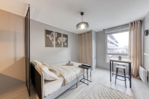 une chambre avec un lit, un bureau et une fenêtre dans l'établissement Charmant Studio 15 minutes from Paris, à Rosny-sous-Bois