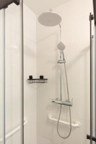 une douche avec une pomme de douche et une porte vitrée dans l'établissement Charmant Studio 15 minutes from Paris, à Rosny-sous-Bois