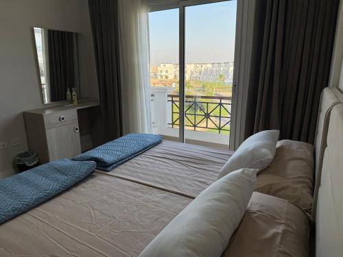 a bedroom with a bed and a large window at Villa Mountain View 4 October in ‘Ezbet `Abd el-Ḥamîd