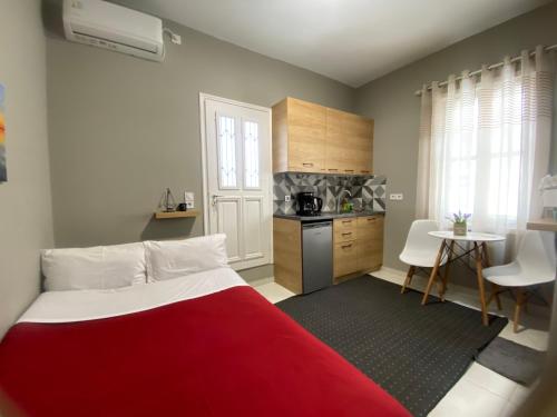 a bedroom with a red bed and a kitchen at The Central Retreat 4 in Mytilini