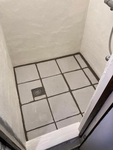 a corner of a bathroom with a ceiling with tiles at Travelers House おーさんてぃん青空舎 in Taketomi