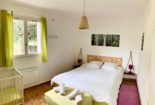a bedroom with a white bed and a window at Gîte L’oliveraie D’Aniane 2 personnes in Aniane