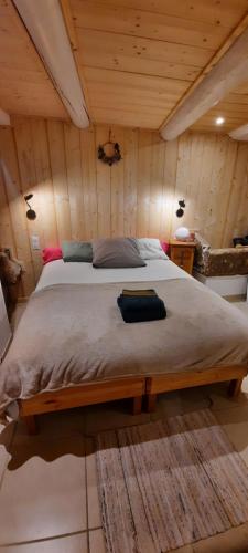 un grand lit dans une chambre aux murs en bois dans l'établissement Maison de village Bédoin, à Bédoin