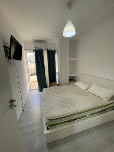 a bedroom with a bed and a television and a window at Shengjin x6 in Shëngjin