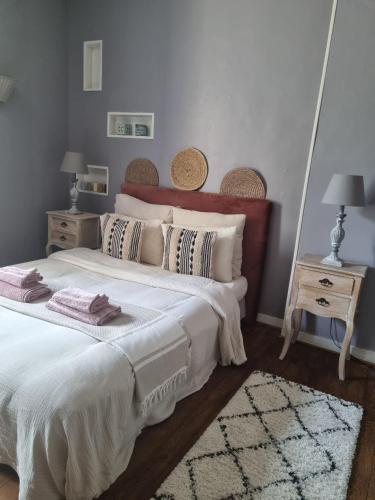 - une chambre avec un grand lit blanc et 2 tables dans l'établissement Charmante maison ancienne avec cour, à Aleçon