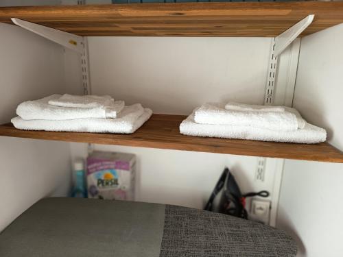 two towels on a wooden shelf in a bedroom at Appartement Belsol Ambiance tropicale et détente in Sada