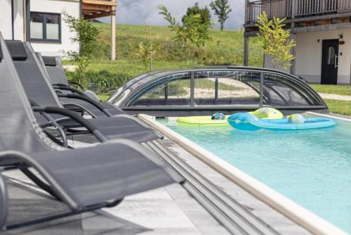 a pool with chairs and a car in the water at Luxalps- Chalets Inzell- Sauna- Skifahren- Wandern- Natur- Chiemgau Card in Inzell