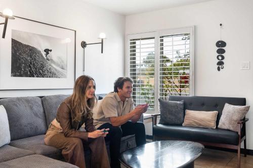 a man and woman sitting on a couch in a living room at San Diego Chill House with Jacuzzi-Golf-Game Room in San Diego