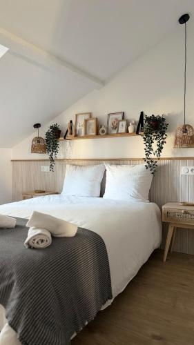 ein Schlafzimmer mit einem großen Bett mit weißer Bettwäsche in der Unterkunft Appartement charmant et cosy Encombe vineuse-DABNB in Limoges