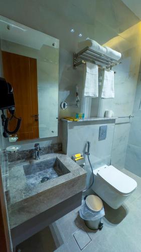 a bathroom with a toilet and a sink at جوهرة العليا للشقق المخدومة in Tabuk