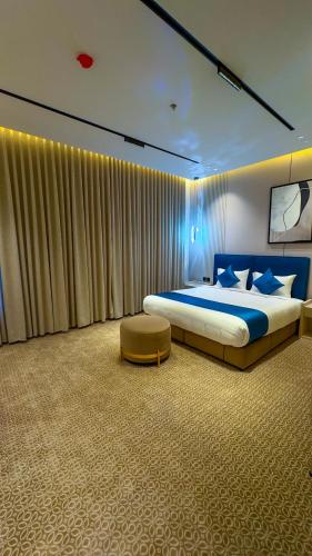 a bedroom with a king sized bed and a chair at جوهرة العليا للشقق المخدومة in Tabuk