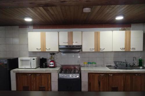 a kitchen with a stove and a microwave at Habitación privada Candelaria 2 in Bogotá