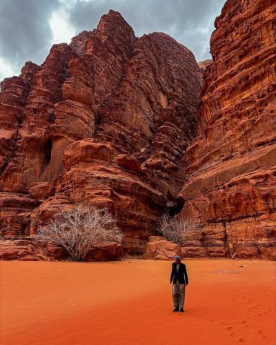 a man standing in the desert near some rocks at Wadi Rum Quiet Desert in Wadi Rum